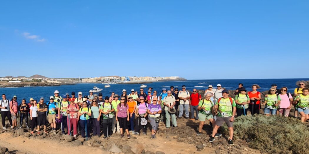 Senderistas reunidos frente al mar