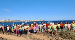 Senderistas reunidos frente al mar