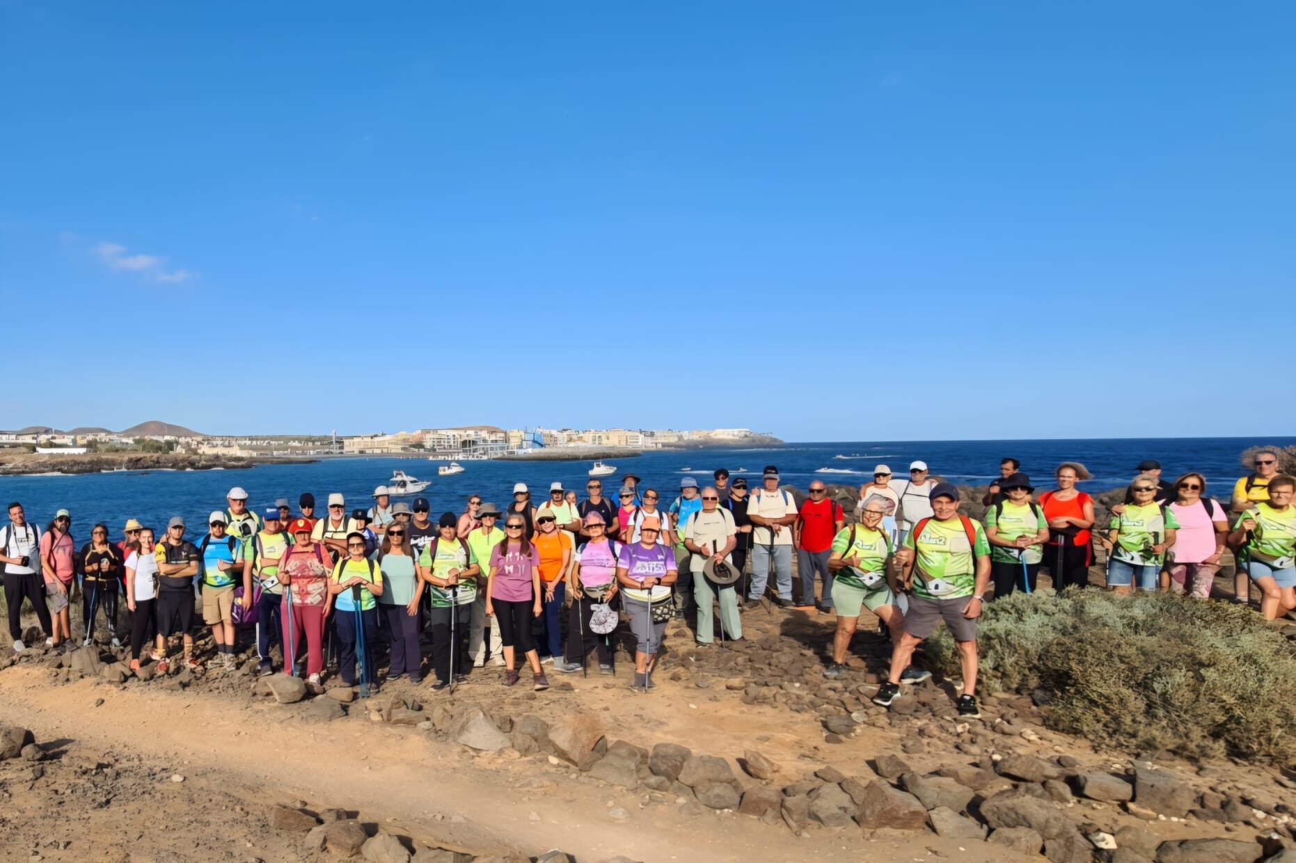 Senderistas reunidos frente al mar